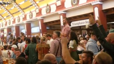 Münih, Almanya - 17 Eylül 2022: Dünyaca ünlü bira festivalinin ilk günü, Oktoberfest. İnsanlar çadırda oturur, bira içer, yer ve kutlarlar. # İşte oldu #.