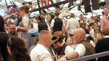 Münih, Almanya - 17 Eylül 2022: Dünyaca ünlü bira festivalinin ilk günü, Oktoberfest. İnsanlar çadırda oturur, bira içer, yer ve kutlarlar. # İşte oldu #.