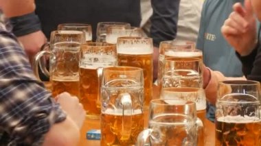 Münih, Almanya - 17 Eylül 2022: Dünyaca ünlü bira festivalinin ilk günü, Oktoberfest. İnsanlar çadırda oturur, bira içer, yer ve kutlarlar. Bira dolu büyük bir litre bardak..
