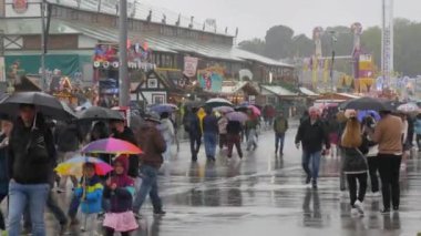 Münih, Almanya - 17 Eylül 2022: Ekim Festivali bira festivalinin ilk günü. Theresienwiese 'de şemsiyeler altında bir kalabalık. Ulusal Bavyera kıyafetleri içindeki kalabalık Dirndl ve Lederhosen.