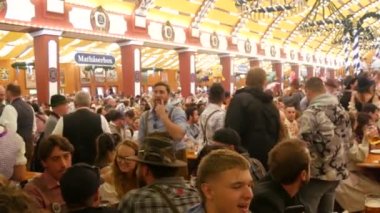 Münih, Almanya - 17 Eylül 2022: Dünyaca ünlü bira festivalinin ilk günü, Oktoberfest. İnsanlar çadırda oturur, bira içer, yer ve kutlarlar. # İşte oldu #.