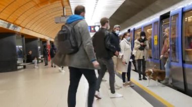 Münih, Almanya - 17 Eylül 2022: tıbbi maskeli ve maskesiz bir kalabalık, dışarı çıkın ve metro istasyonunda oturun..