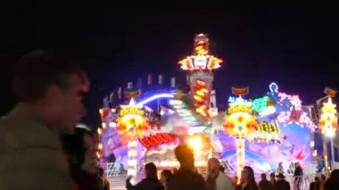 Münih, Almanya - 17 Eylül 2022: Renkli parlayan binişler, atlıkarıncaların ve salıncakların gece görüşü. Dünyaca ünlü bira festivali Oktoberfest 'in ziyaretçileri. Theresienwiese 'deki kalabalık.