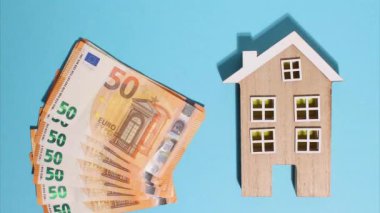 Hareket animasyonunu durdurun. Avro parası. Finansal kriz. Doku. Finans İşletmeleri Yatırım Başarı Konsepti. Ahşap ev ve Euro para hayranı. Mavi arka planda en üstten 50 Euro 'luk banknotlar görünüyor..