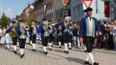 Buhl, Almanya - 11 Eylül 2022: Şehir sokaklarındaki erik hasadının onuruna düzenlenen şenlik geçidi. Antika mavi kıyafetler giymiş bir bando sokakta yürüyor, seyirciler izliyor..