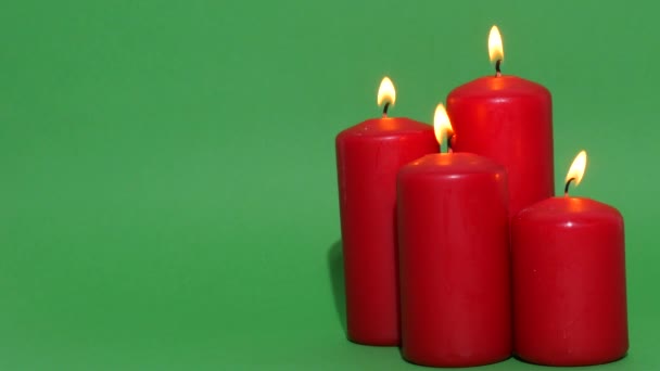 Dicke Rote Weihnachtskerzen Auf Grünem Hintergrund Die Kerzenflamme Brennt Und — Stockvideo
