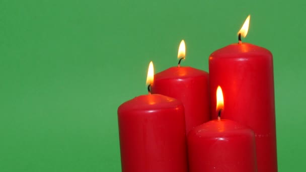 緑のクロマキーの背景に厚い赤いクリスマスのろうそく ろうそくの炎が燃え踊り — ストック動画