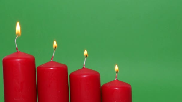 緑のクロマキーの背景に厚い赤いクリスマスのろうそく ろうそくの炎が燃え踊り — ストック動画