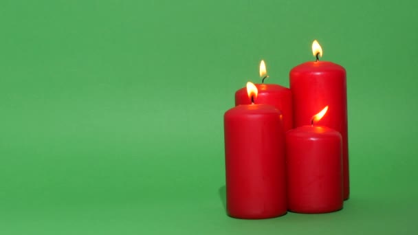 浓密的红色圣诞蜡烛在绿色的彩色键背景上 蜡烛的火焰燃烧着跳舞 — 图库视频影像