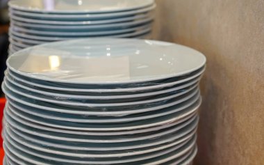 Sterilize edilmiş plastikle sarılı boş yuvarlak yemek tabağı seçici odak noktasında.