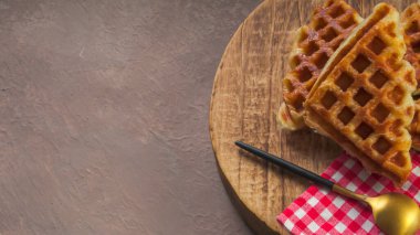 Yuvarlak ahşap yüzey tabağında servis edilen Croffle veya Croffle. Seçici odak resmi.