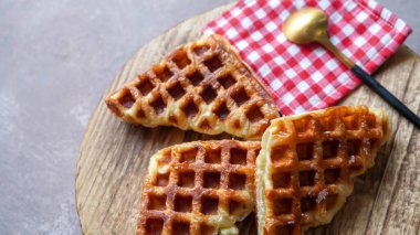 Yuvarlak ahşap yüzey tabağında servis edilen Croffle veya Croffle. Seçici odak resmi.