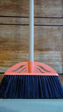 Yerleri süpürmek için gri tüylü sarı plastik süpürge seti ve beyaz arka planda faraş, seçici odak noktasında çalışan kısımlar.