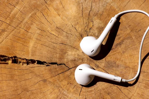 White modern  earphones, headset, on wood table