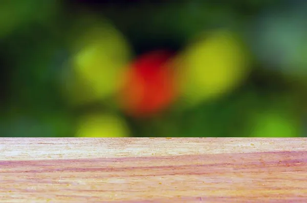 Drewniana Deska Pusty Stół Przed Zielonym Czerwonym Bokeh Tle Wyświetlania — Zdjęcie stockowe