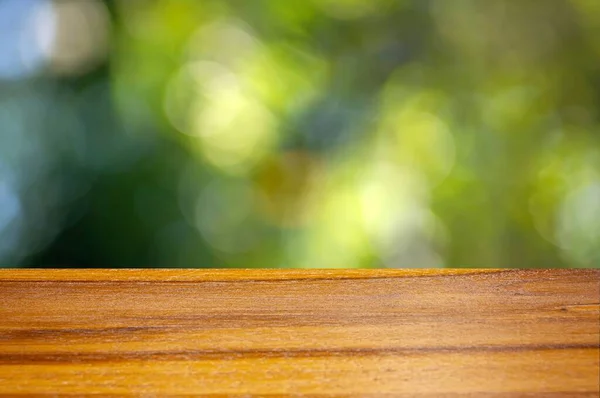 Dřevěná Deska Prázdný Stůl Před Zeleným Bokeh Pozadí Pro Zobrazení — Stock fotografie