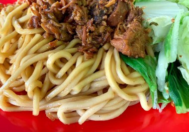 Mie Goreng 'e yakın durun ya da kırmızı tabakta tavuk ve sebzeyle servis edilen kızarmış şehriye.