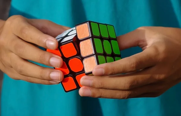 Renkli bir rubik küp bulmacası oynayan bir çocuk