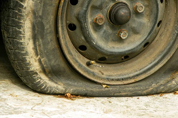 Close up of flat tire of an old rusty car