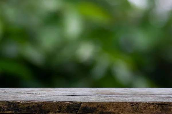 Ürün görüntülemek için eski ahşap masa yeşil ve sarı bokeh soyut arkaplan önünde