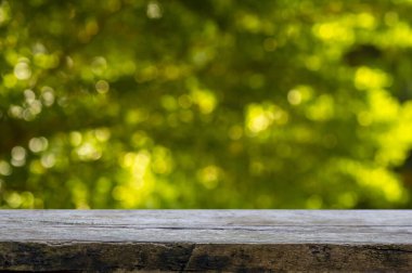 Ürün görüntülemek için eski ahşap masa yeşil ve sarı bokeh soyut arkaplan önünde