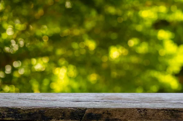 Ürün görüntülemek için eski ahşap masa yeşil ve sarı bokeh soyut arkaplan önünde