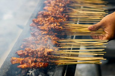 Yogyakarta, Endonezya 'dan geleneksel bir satay olan Sate Ayam veya Chicken Satay, yüzeysel odak ve hareket bulanık arka planda