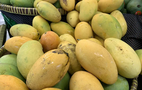 Süpermarkette bir yığın taze tropikal mango.