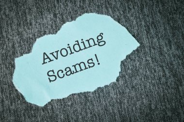 AVOIDING SCAMS ile yazılmış mavi yırtık kağıt!