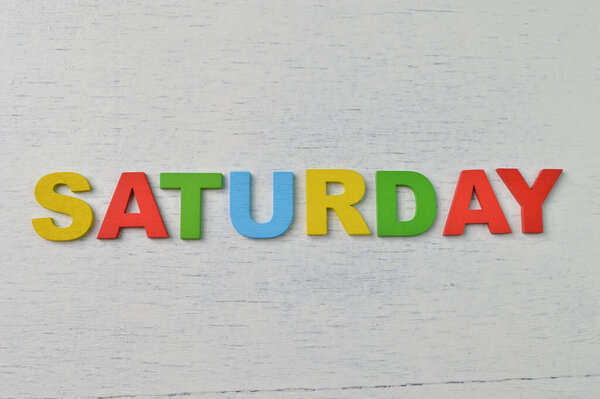 Colorful wooden alphabet with text SATURDAY. A happy Saturday concept