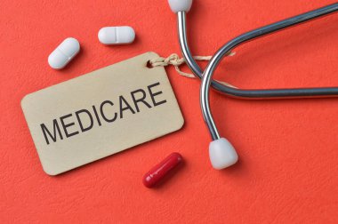 İlaç kapsülleri, steteskop ve etiket MEDICARE ile yazıldı.