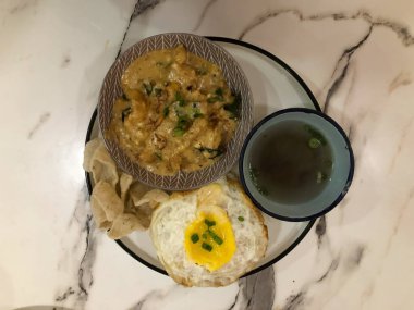 Yumurta, çorba, tereyağı ve kraker ile servis edilen beyaz pirinç manzarası veya halk arasında Nasi Telur Masin Butter olarak bilinir..