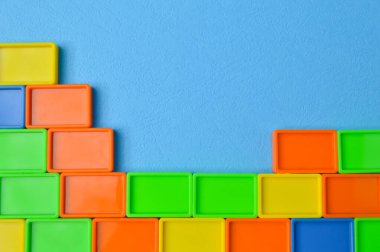 Mavi arka planda izole edilmiş plastik oyuncak yapı taşları