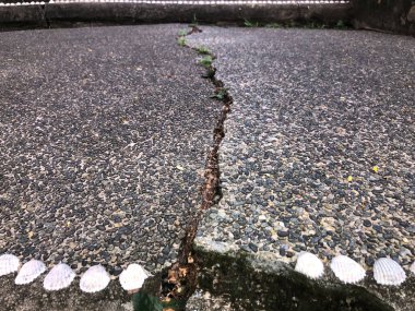 Crack in grey concrete surface on the road