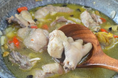 Close up view of chicken soup in a pot broth of boiling water