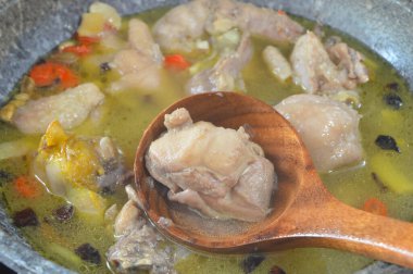 Close up view of chicken soup in a pot broth of boiling water