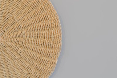 Round woven placemat isolated on a grey background