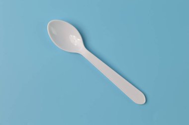 Plastik kaşık mavi arkaplanda izole edilmiş.