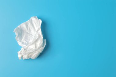 Mavi arka planda izole edilmiş beyaz buruşmuş doku. Hijyen, sağlık ve güvenlik kavramı.