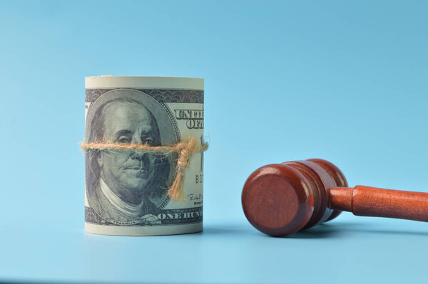 Банкноты и молоток судьи изолированы на синем фоне