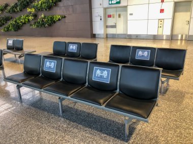 Havaalanı terminalindeki koltukta sosyal uzaklık sembolleri