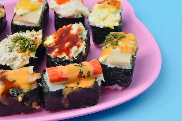 Pembe tabakta Japon deniz ürünleri suşisi. Maki ve rulo ton balığı, somon karidesi, yengeç ve avokado..