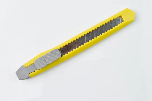 白い背景に独立した刃を持つ黄色の文房具ナイフ 学校及び事務用品 — ストック写真