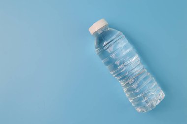 Mavi arka planda su izole edilmiş plastik şişe.