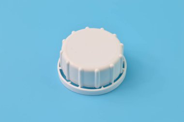 Mavi arka planda izole edilmiş beyaz şişe kapağının yakın görüntüsü