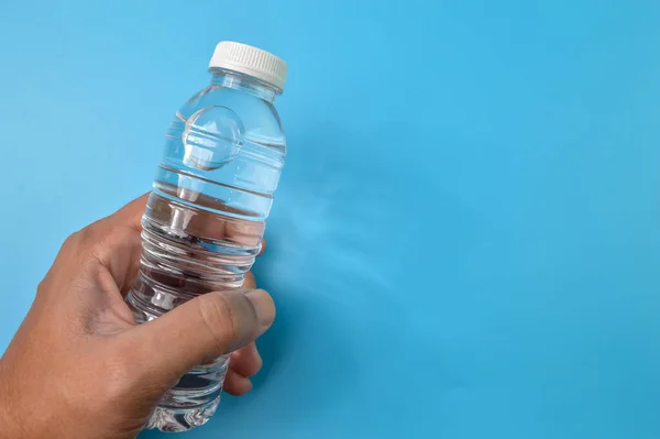 Ręczne Trzymanie Wody Mineralnej Odizolowanej Niebieskim Tle — Zdjęcie stockowe