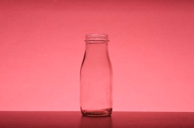 Kırmızı zemin üzerinde beyaz cam şişe izole