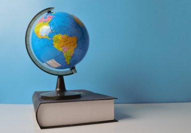 Earth globe and book on the table. Copy space for the text.