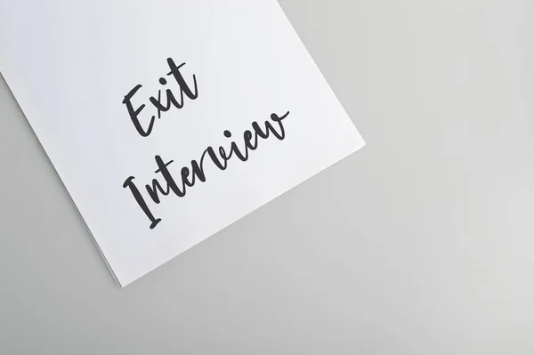 White paper written with text EXIT INTERVIEW isolated on a grey background