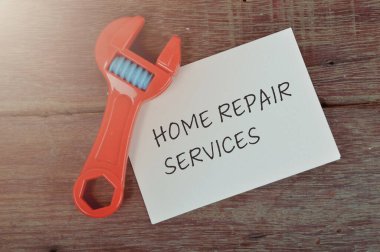 Oyuncak anahtar ve beyaz kağıt. Ev Onarım Servisi cümlesiyle yazılmış.